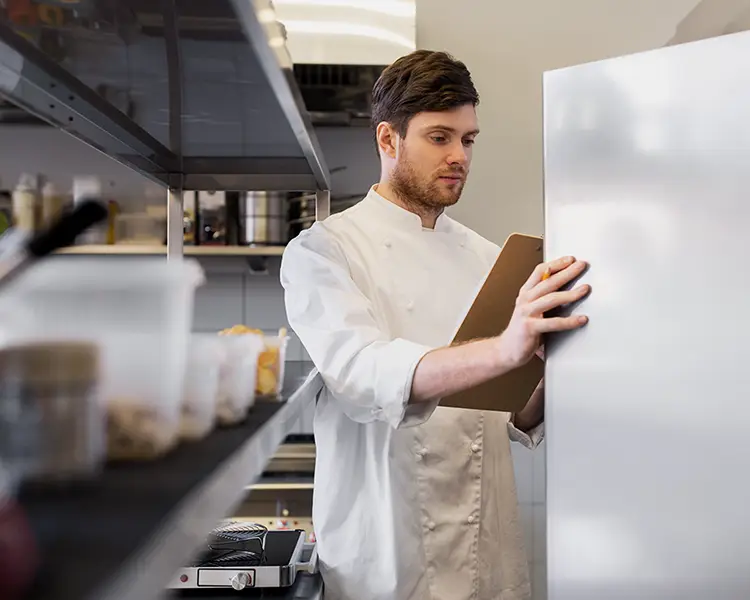 Chef dans sa cuisine ouvrant le frigo